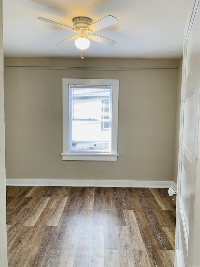 unfurnished room featuring wood finished floors, baseboards, and ceiling fan