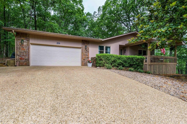 view of front of house featuring stone siding, driveway, and a garage