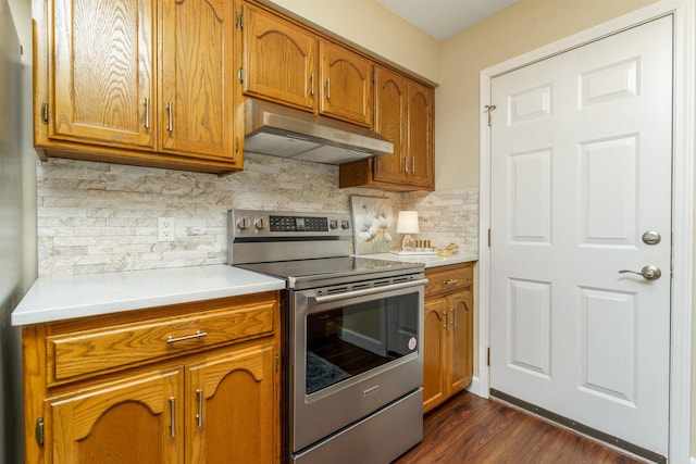 kitchen with stainless steel electric range, under cabinet range hood, brown cabinets, and light countertops