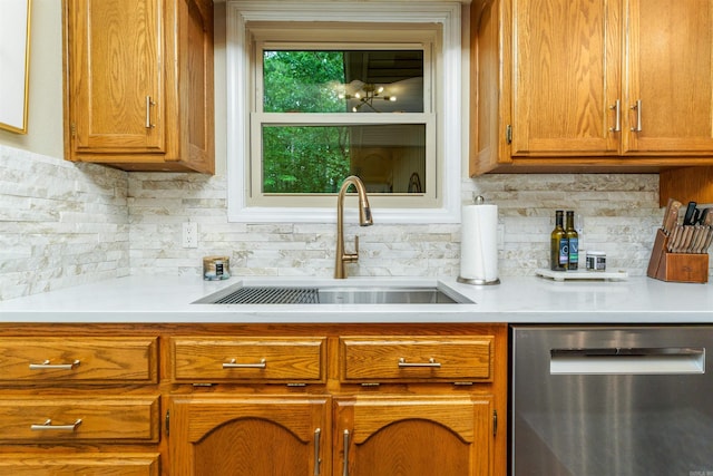 kitchen with dishwasher, a sink, brown cabinetry, and light countertops