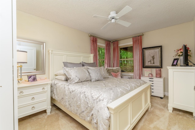 bedroom with light colored carpet, a textured ceiling, and ceiling fan