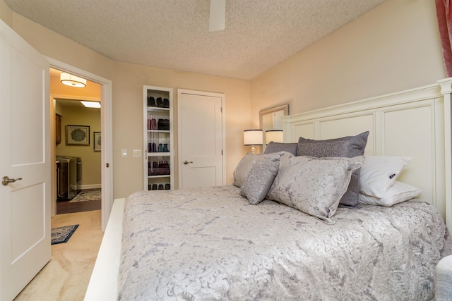 carpeted bedroom featuring a textured ceiling and a ceiling fan