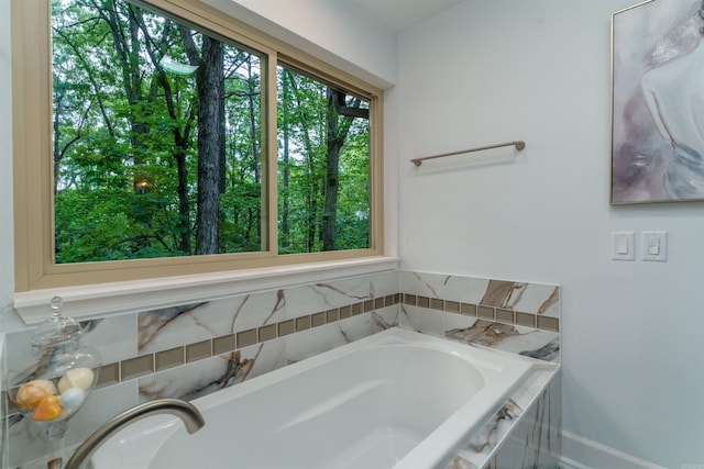 full bath with a garden tub and baseboards