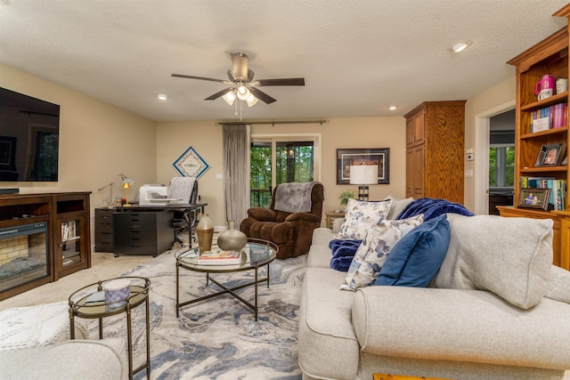 carpeted living area featuring a ceiling fan, an office area, recessed lighting, and a textured ceiling
