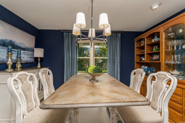 dining area featuring a chandelier and a textured ceiling