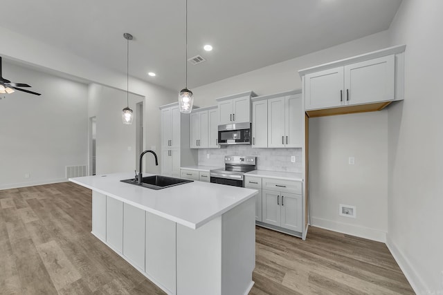 412 N 3rd St, Cabot, AR 72023 - kitchen with stainless steel appliances, a sink, light wood-style floors, backsplash, and a ceiling fan