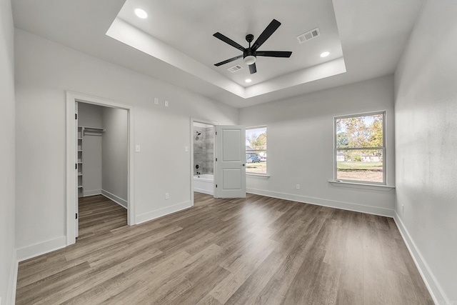 412 N 3rd St, Cabot, AR 72023 - unfurnished bedroom featuring a tray ceiling, wood finished floors, baseboards, a walk in closet, and recessed lighting