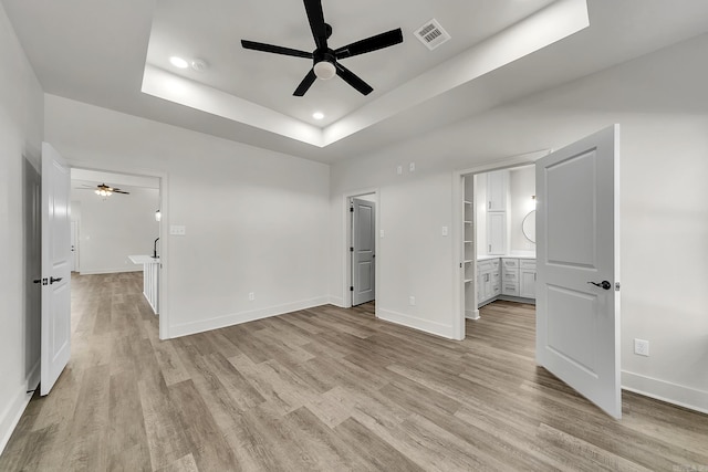 412 N 3rd St, Cabot, AR 72023 - unfurnished bedroom with a raised ceiling, light wood-style floors, baseboards, recessed lighting, and connected bathroom