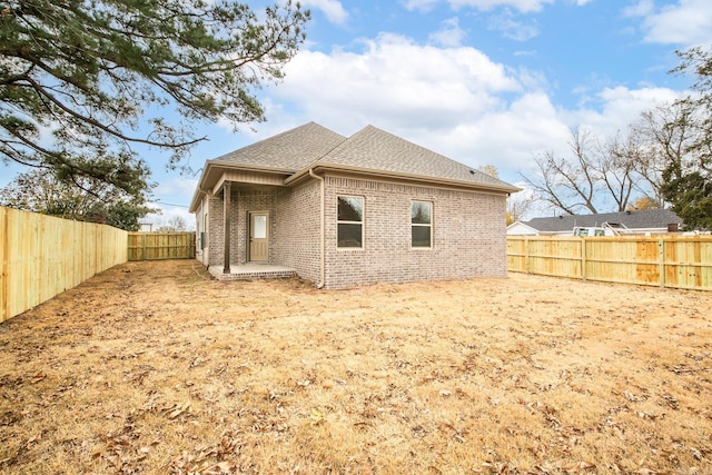 412 N 3rd St, Cabot, AR 72023 - back of property with brick siding, a shingled roof, and a fenced backyard