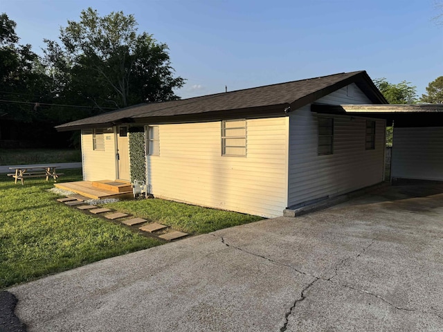 810 N Pear St, Searcy, AR 72143 - view of home's exterior featuring concrete driveway, a carport, a yard, and a shingled roof