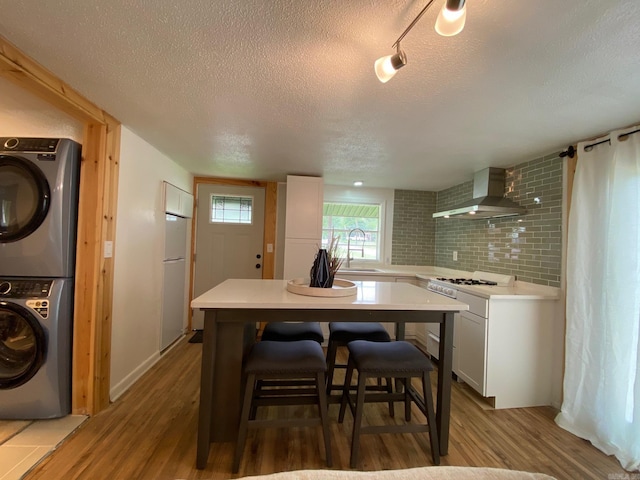 810 N Pear St, Searcy, AR 72143 - kitchen featuring wall chimney exhaust hood, stacked washer / drying machine, a sink, a textured ceiling, and fridge