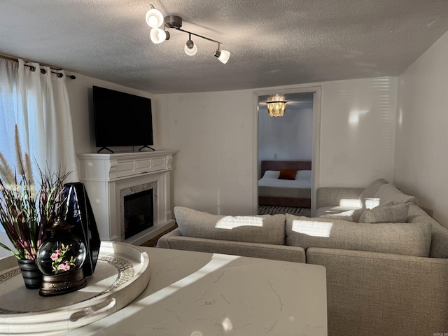 810 N Pear St, Searcy, AR 72143 - living area featuring a textured ceiling, a high end fireplace, and rail lighting