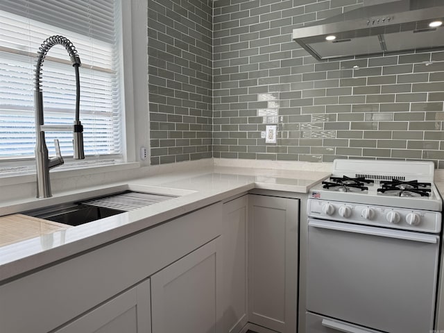 810 N Pear St, Searcy, AR 72143 - kitchen with gas range gas stove, wall chimney exhaust hood, a sink, tasteful backsplash, and light stone counters