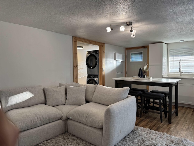 810 N Pear St, Searcy, AR 72143 - living area with stacked washing machine and dryer, light wood-style flooring, and a textured ceiling