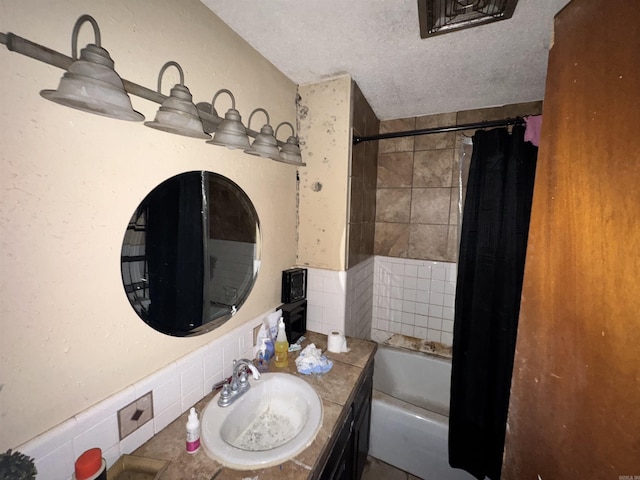 1416 Dogwood Trl, Malvern, AR 72104 - bathroom featuring vanity, shower / bath combo with shower curtain, a textured ceiling, and wainscoting