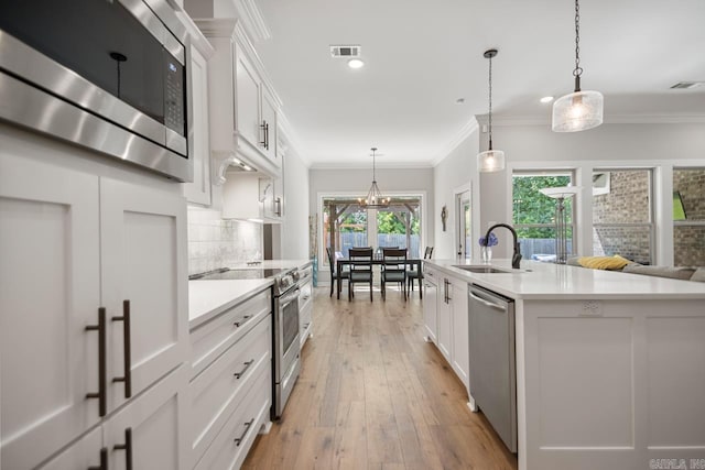 1449 Woolridge Dr, Benton, AR 72019 - kitchen with stainless steel appliances, a sink, light countertops, white cabinetry, and recessed lighting