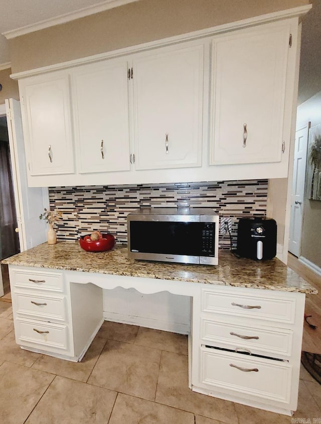 9 Apple Tree Cir, Little Rock, AR 72210 - kitchen view of stainless steel microwave, backsplash, white cabinetry, crown molding, and light stone counters