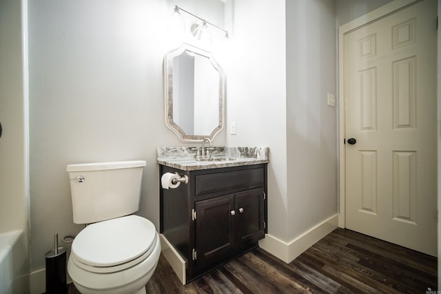 2330 Tyler St, Conway, AR 72034 - bathroom featuring wood finished floors, vanity, baseboards, and toilet