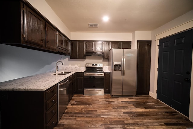 2330 Tyler St, Conway, AR 72034 - kitchen with appliances with stainless steel finishes, under cabinet range hood, a sink, dark wood-style flooring, and dark brown cabinetry