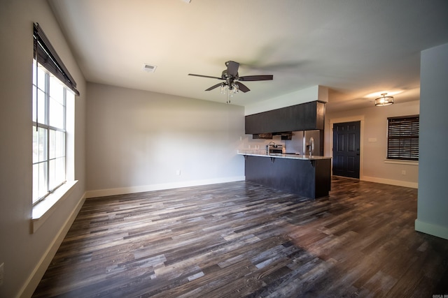 2330 Tyler St, Conway, AR 72034 - unfurnished living room with dark wood-type flooring, baseboards, and a ceiling fan