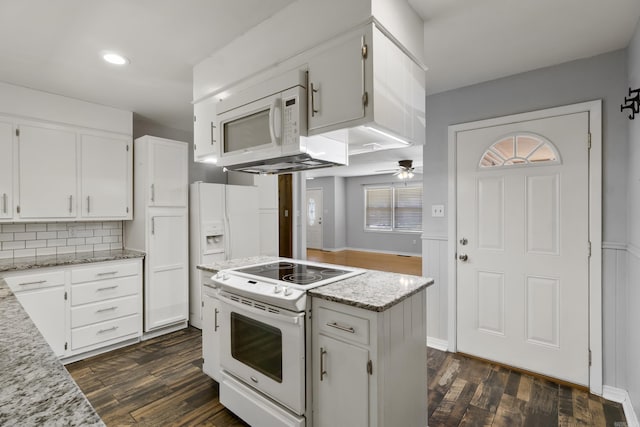 kitchen with white appliances, dark wood finished floors, white cabinets, and recessed lighting