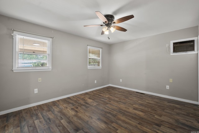 spare room featuring a wall mounted AC, a ceiling fan, and baseboards