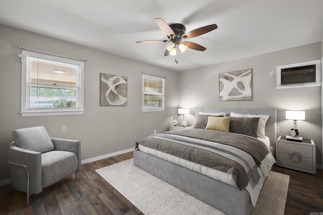bedroom with an AC wall unit, dark wood-style flooring, baseboards, and ceiling fan