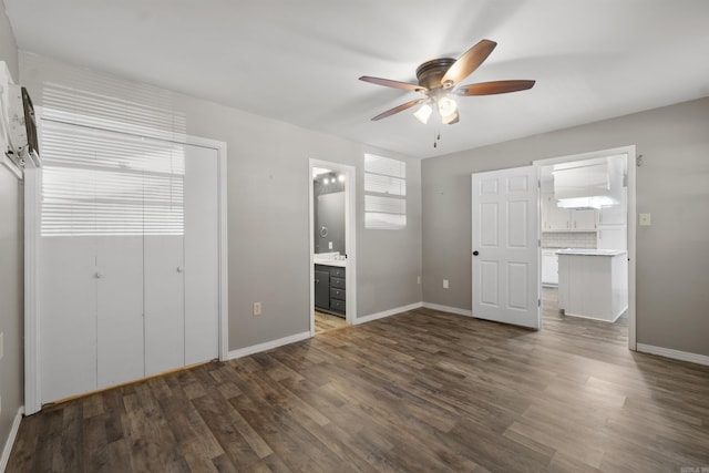 unfurnished bedroom with dark wood-type flooring, a closet, and baseboards