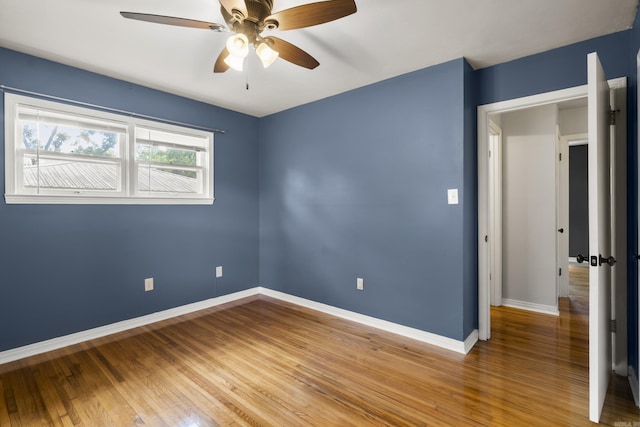 empty room with baseboards, a ceiling fan, and light wood-style floors