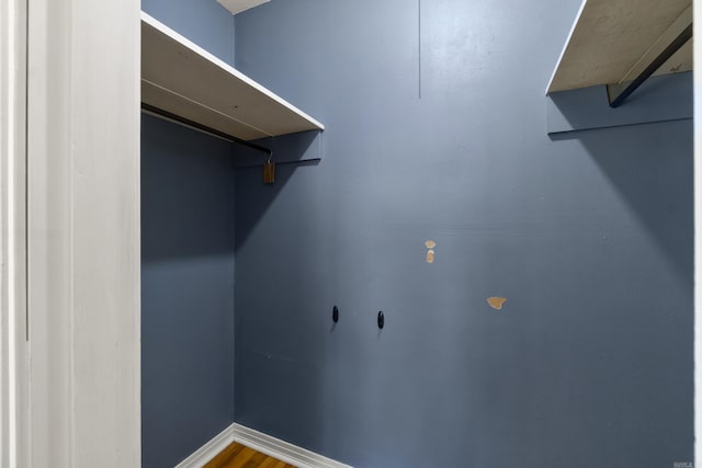 walk in closet with wood finished floors