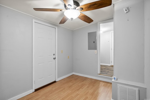 unfurnished room with electric panel, a ceiling fan, light wood-type flooring, and baseboards