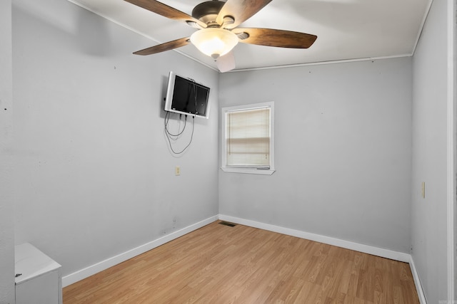 spare room featuring light wood-style floors, ceiling fan, and baseboards