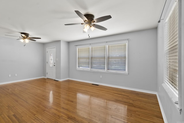 spare room with a ceiling fan and baseboards