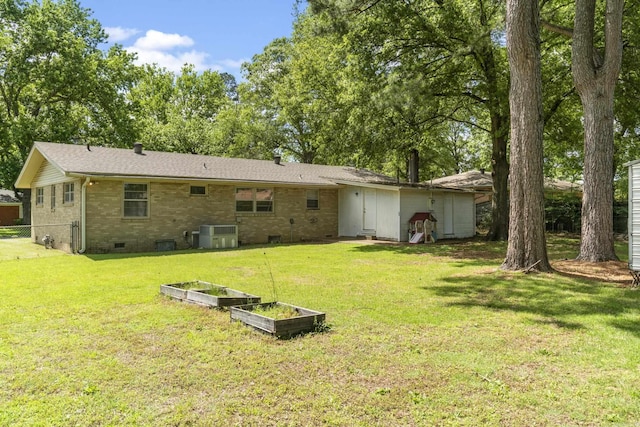 rear view of house featuring brick siding, a garden, crawl space, and cooling unit