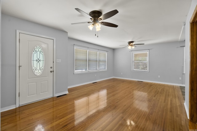 foyer with a ceiling fan, baseboards, and wood finished floors
