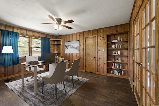 office area featuring wood walls, ceiling fan, dark wood-style floors, and baseboards