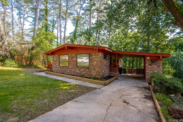 18 Woodcliff Cir, Little Rock, AR 72204 - view of home's exterior featuring concrete driveway, brick siding, a lawn, and a carport