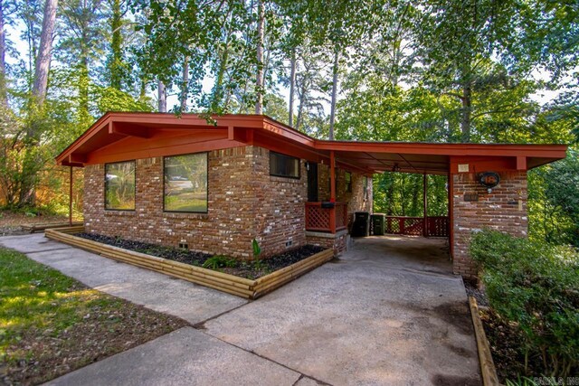 18 Woodcliff Cir, Little Rock, AR 72204 - view of home's exterior featuring driveway, brick siding, and a carport