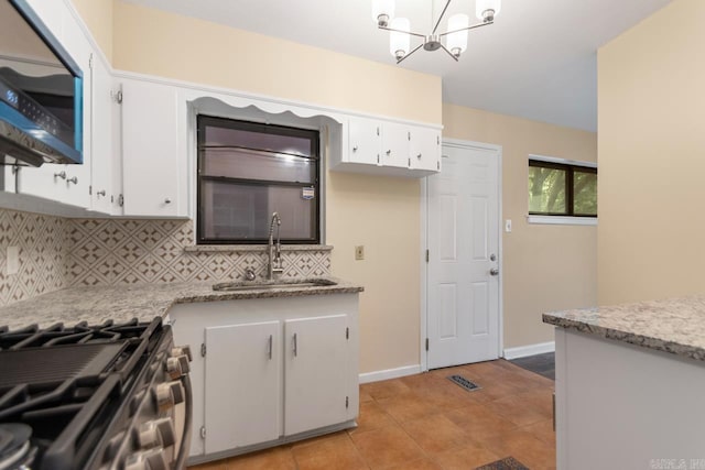 18 Woodcliff Cir, Little Rock, AR 72204 - kitchen featuring a sink, stainless steel appliances, backsplash, white cabinetry, and a chandelier