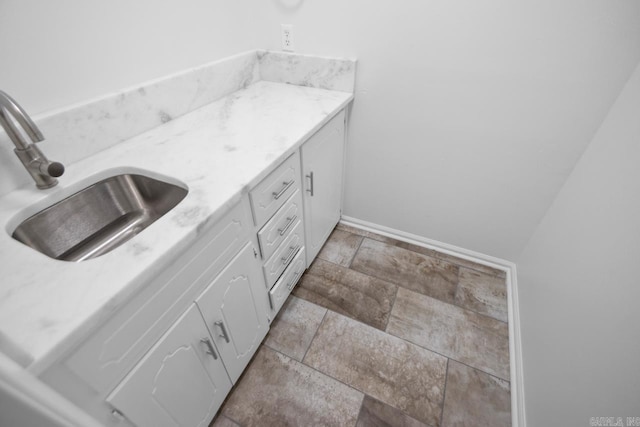 3 Poydras Dr, Little Rock, AR 72211 - bathroom with stone finish floors, vanity, and baseboards