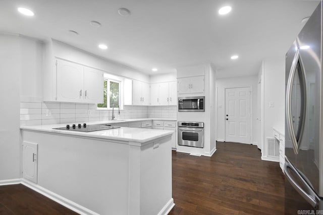 3 Poydras Dr, Little Rock, AR 72211 - kitchen with appliances with stainless steel finishes, a peninsula, white cabinets, dark wood-style flooring, and recessed lighting