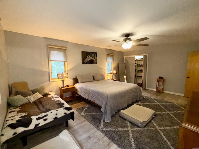 bedroom featuring wood finished floors, a ceiling fan, and baseboards