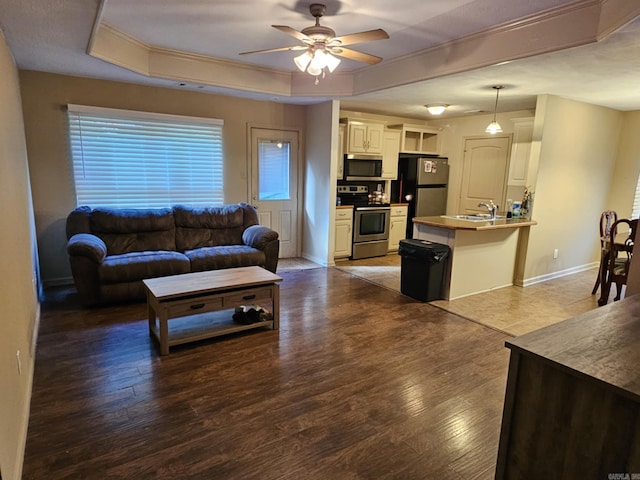 216 Plum Dr, Austin, AR 72023 - living area featuring a raised ceiling, a ceiling fan, wood finished floors, crown molding, and baseboards