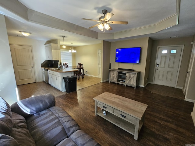 216 Plum Dr, Austin, AR 72023 - living area with a tray ceiling, a ceiling fan, baseboards, wood finished floors, and a chandelier