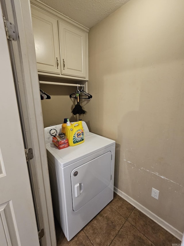 216 Plum Dr, Austin, AR 72023 - laundry room featuring washer / dryer, cabinet space, dark tile patterned flooring, baseboards, and a textured ceiling