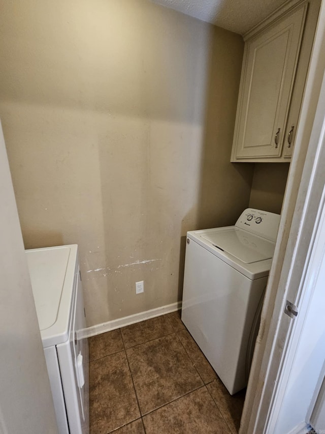 216 Plum Dr, Austin, AR 72023 - washroom with washer and clothes dryer, cabinet space, dark tile patterned floors, and baseboards