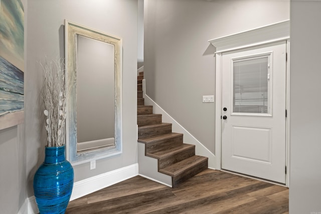 foyer with stairway, dark wood-style floors, and baseboards