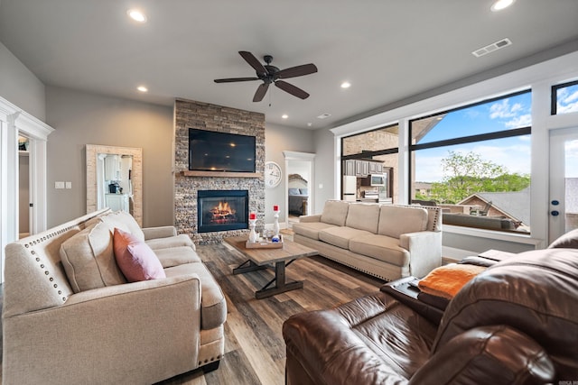 living room with wood finished floors, ceiling fan, recessed lighting, and a stone fireplace