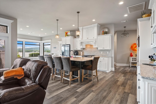 kitchen featuring open floor plan, stainless steel appliances, dark wood-type flooring, white cabinetry, and recessed lighting
