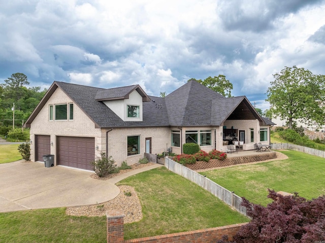view of front facade with a garage, concrete driveway, a front yard, and brick siding